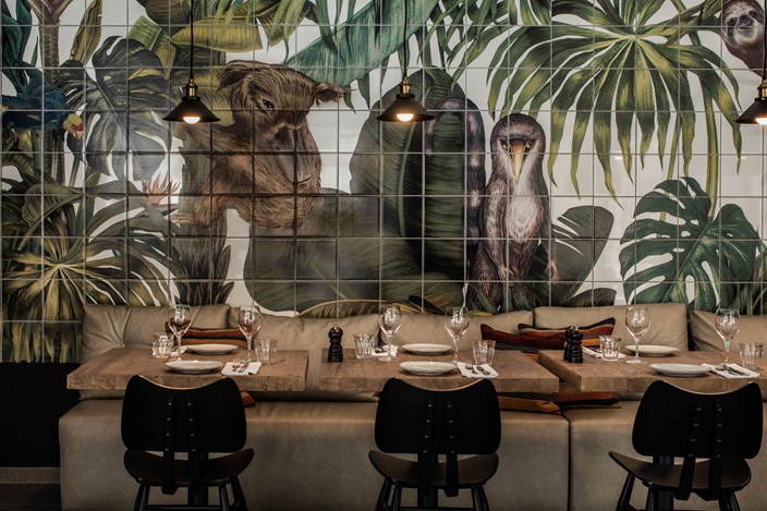 Casa Cook Rhodes Greece Kitchen Club Restaurant seating with tropical forest and animal wallpaper behind the table
