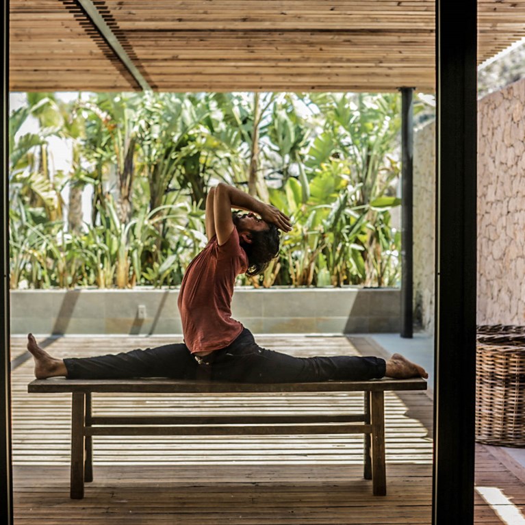 Casa Cook Rhodes Greece man doing yoga on a bench in the open air yoga Shala